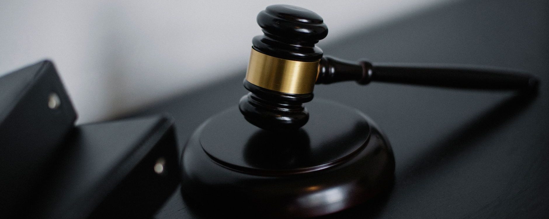 A gavel and its block on a dark desk